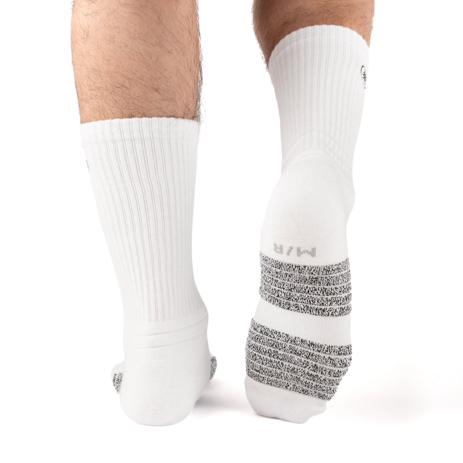 White Performance Crew Socks worn on model, rear view showing high-friction footbed