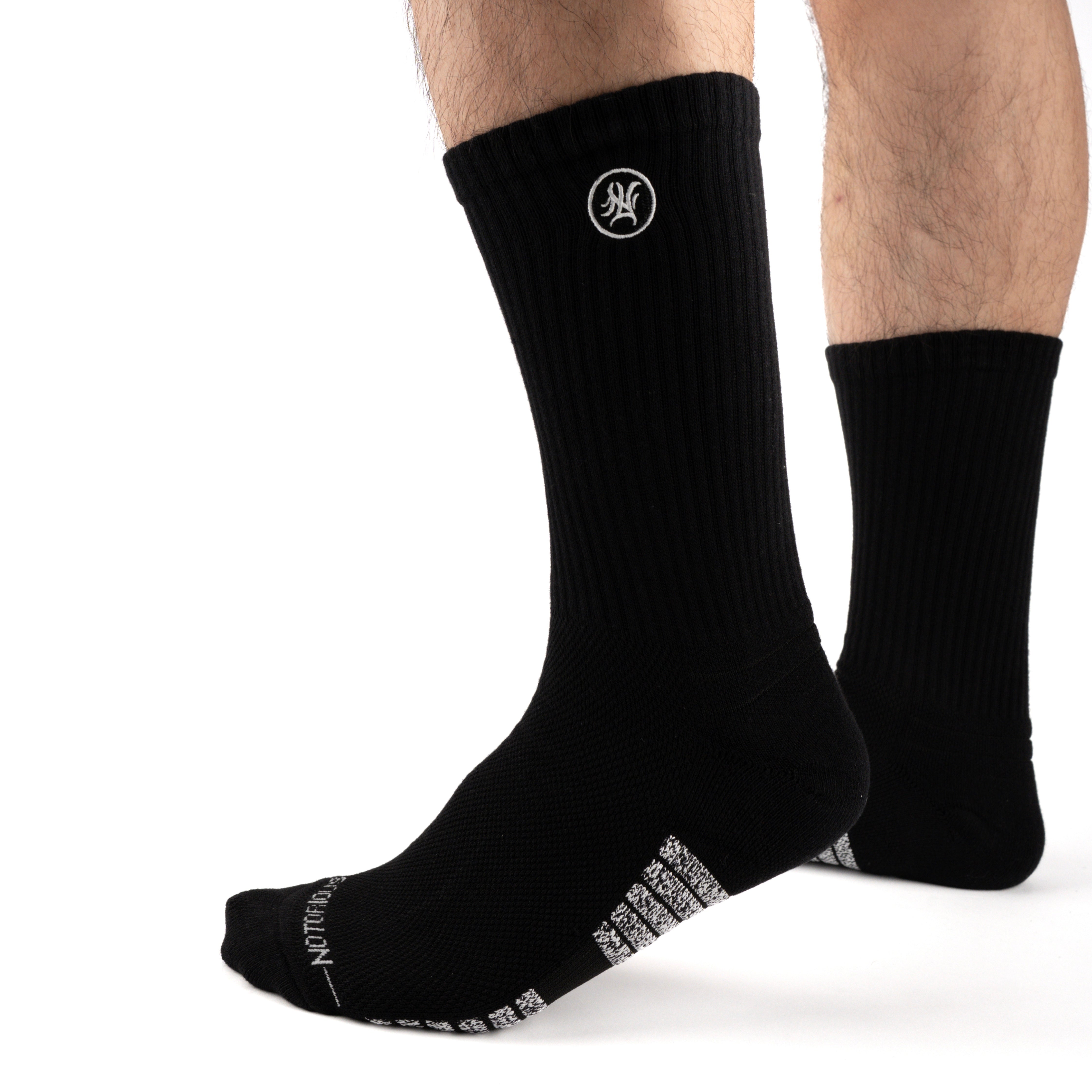 Black Performance Crew Socks worn on model, front three-quarter view