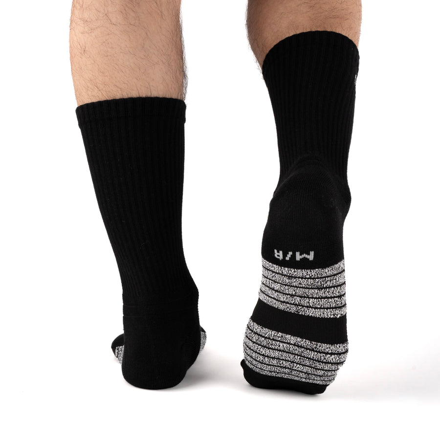 Black Performance Crew Socks worn on model, rear view showing high-friction footbed